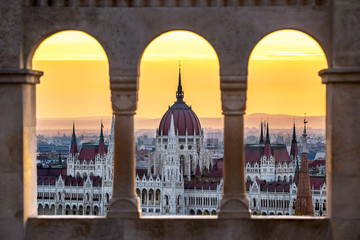 Obraz premium Budapest, Hungary - The Hungarian Parliament building at sunrise looking through old stone windows