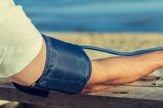 Hypertensive patient performing an automatic blood pressure test on the beach