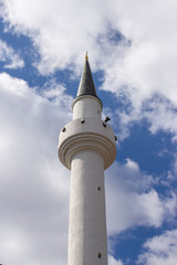 Obraz premium Minaret of a Muslim mosque on the background of the cloudy sky. one minaret staring to heaven, a religious Muslim shrine