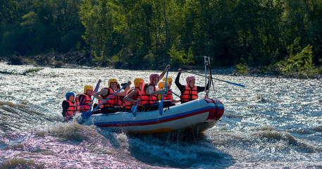 rafting in a big boat on a rough mountain river in summer