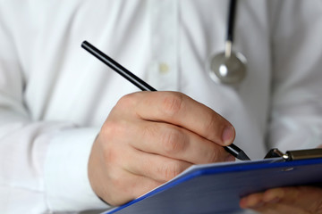 Doctor with stethoscope writes a prescription paper, medical exam. Concept of medicine, diagnosis, therapist, examination at the clinic, health care