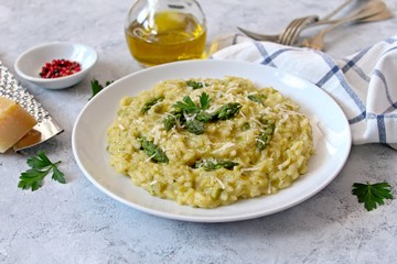 Italian risotto with spring asparagus and parmesan cheese on light background. Top view with copy space.