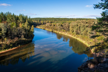 scenic river view landscape of forest rocky stream with trees on the shores