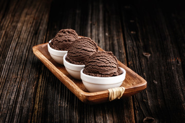 Chocolate ice cream with bowl on wooden background