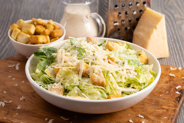 Caesar Salad on a Wooden Table with Grated Parmesan
