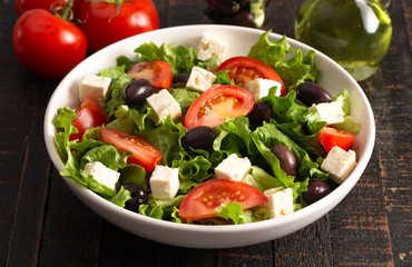 Greek Salad with Olives Tomatos and Feta Cheese on a Rustic Wood Table