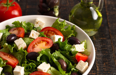 Greek Salad with Olives Tomatos and Feta Cheese on a Rustic Wood Table