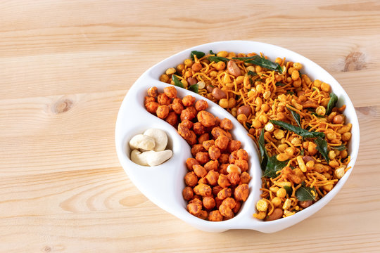 Assortment spicy crunchy indian mix Nimco or Namkeen and spicy coated peanut white bowl wooden background.