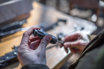 male person soldier cleans the weapon, disassemble, make maintenance of service weapon