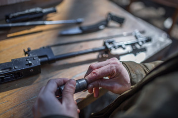 male person soldier cleans the weapon, disassemble, make maintenance of service weapon