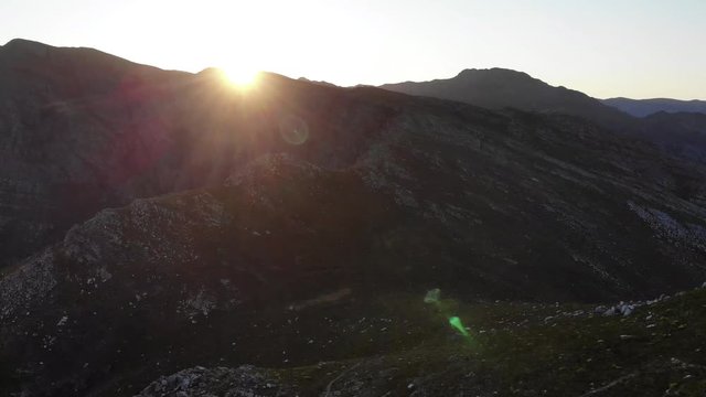 Aerial footage of sunrise over a rugged mountain valley