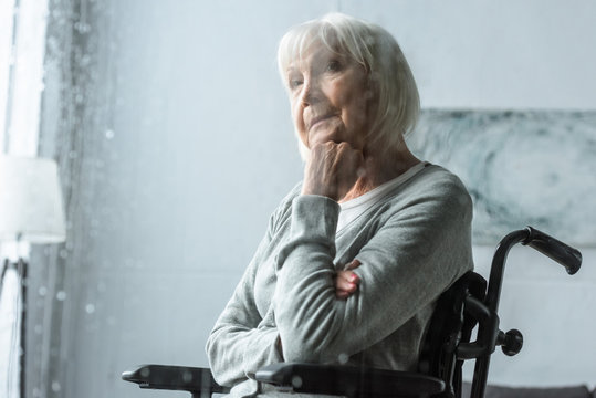 selective focus of pensive disabled senior woman with grey hair
