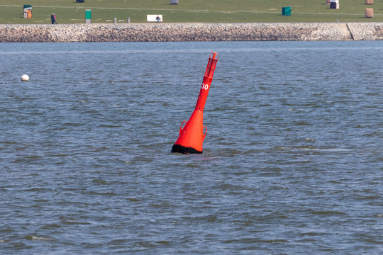 Red Buoy swimming in front of the beach of buesum at the north in germany 