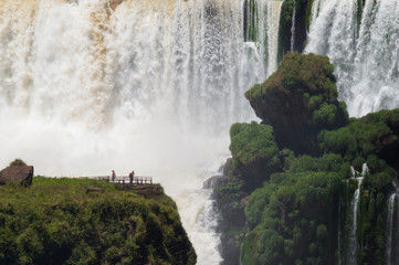 Tourists near huge waterfall at Iguazu National Park, Argentina