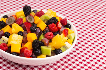 Bowl of Fresh Rainbow Fruit Salad on a Red Plaid Tablecloth