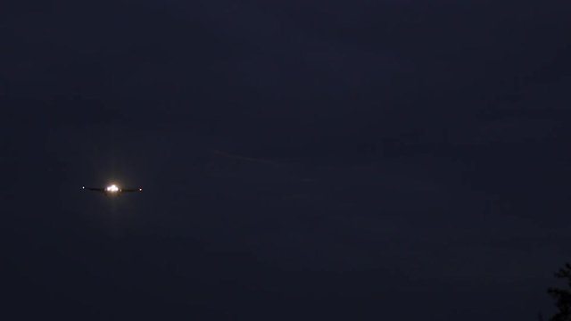 Night video of a flying plane next to Warsaw Chopin Airport in Poland.