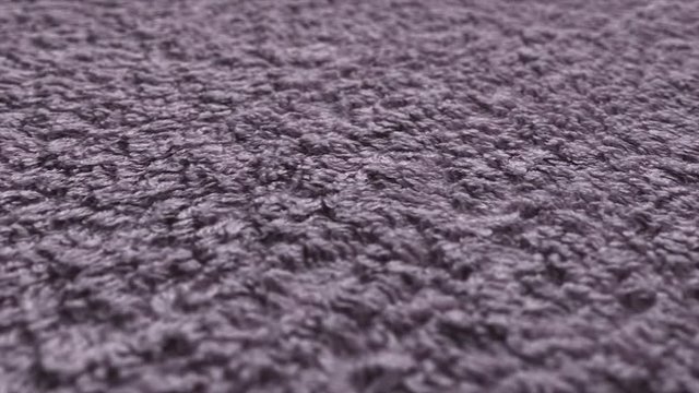 Macro shot of pink fur carpet texture. Close up shot of dirty, rough ground with pan movement. 