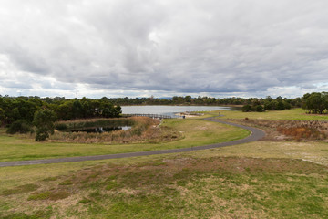 A walk bridge on a large fresh water lake in a community park.