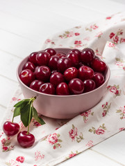 Cherry fresh in a pink plate on a light background