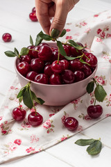 Cherry fresh in a pink plate on a light background