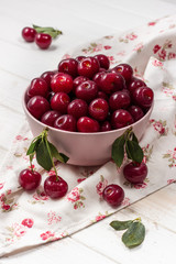 Cherry fresh in a pink plate on a light background