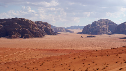 Plakat Panoramic view to the landscape of the Wadi Rum desert with red sand dunes and rocks in Jordan. 