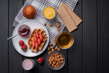 Traditional belgian waffle with strawberry. Sweet homemade breakfast. Delicious. Dessert on black table background