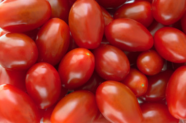 Shiny fresh red plum cherry tomatoes on the market. Close up. Macro.