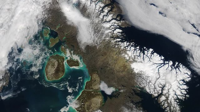 Rotating clouds over ocean sea and winter aerial satellite view mountains and snow. Baffin island and Foxe basin in Canada. Contains public domain image by Nasa