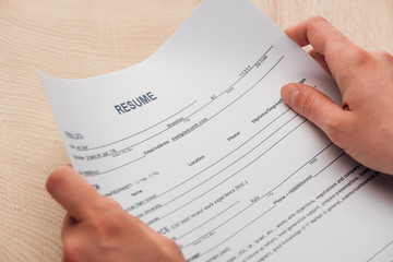 Obraz premium cropped view of recruiter holding resume template in hands