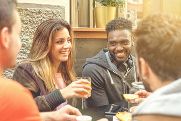 Group of multi-racial friends talking together and having fun at the restaurant table. Focus on the African American guy. People of different races integration concept.