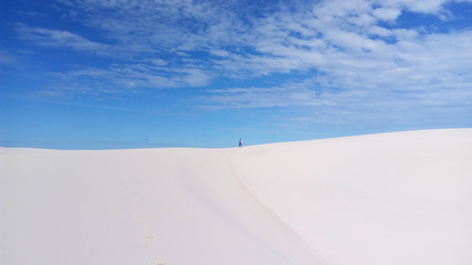 Fototapeta na wymiar walking on top of the dune with blue sky