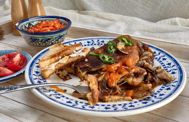 Omelet with fried onions and mushrooms.Baked beans and fresh tomatoes.On a wooden tray.