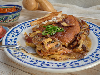 Omelet with fried onions and mushrooms.Baked beans and fresh tomatoes.On a wooden tray.
