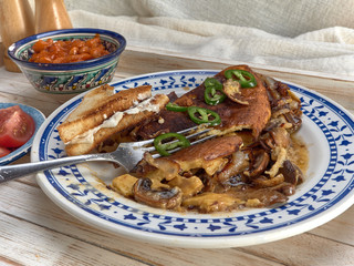 Omelet with fried onions and mushrooms.Baked beans and fresh tomatoes.On a wooden tray.