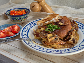 Omelet with fried onions and mushrooms.Baked beans and fresh tomatoes.On a wooden tray.