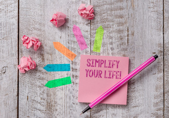 Conceptual hand writing showing Simplify Your Life. Concept meaning focused on important and let someone else worry about less ones Note paper and line arrow stickers on the top of wooden table desk