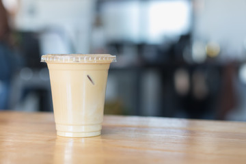 Iced milk coffee in plastic cup with cover.no straw.Indoor cafe
