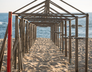 Wooden beach hut frames on the beach in summer with ocean in the background on sunny day in summer.