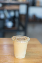 Iced milk coffee in plastic cup with cover.no straw.Indoor cafe