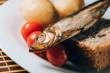 smoked sprat fish on bread home-style white plate