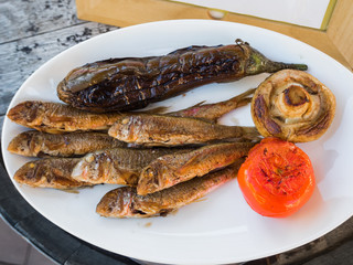 Fried fish on a white plate with pepper