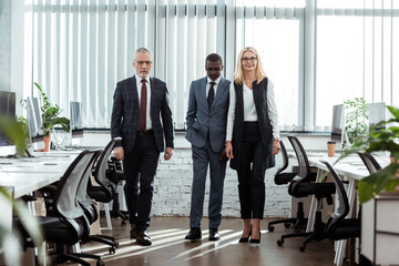 Fototapeta premium selective focus of african american businessman walking near partners in office