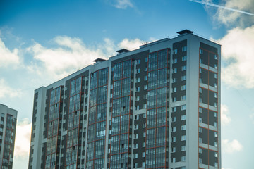 Fototapeta premium Windows of a high multi-storey residential building. High building. Residential high-rise building.