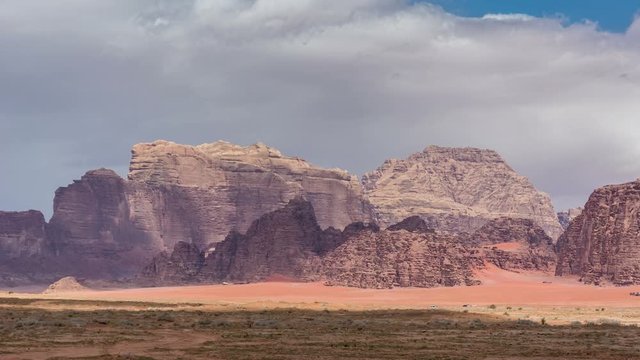 Stone desert landscape, clouds move fast above rocks. Time lapse video.