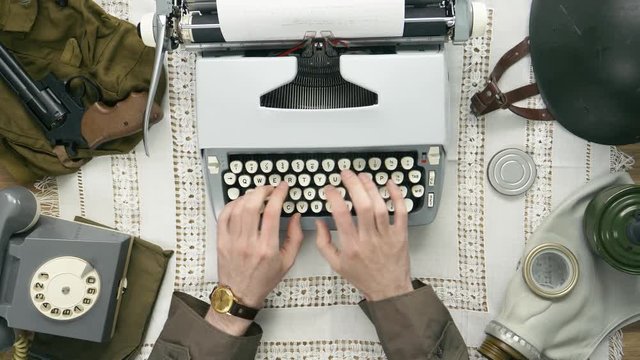 A soldier typing a letter on a typewriter. 50's 60's 70's vintage scene. Historical reenactment concept.
