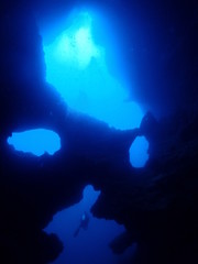 Fototapeta na wymiar A diver swims in the underwater cave.