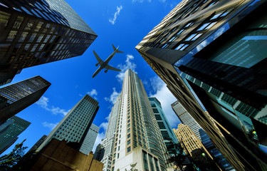 Fototapeta na wymiar Looking up at New York city skyscrapers in financial district, NYC USA plane flying