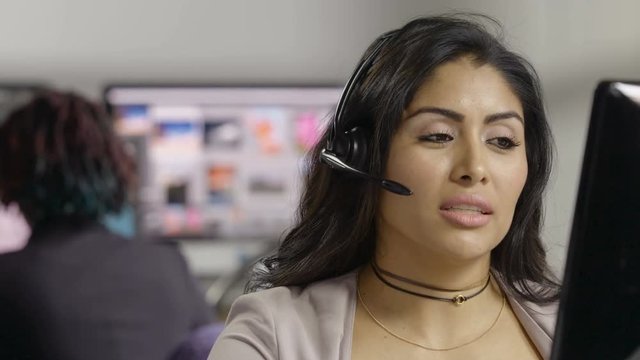 Young female customer service representative talking with headset