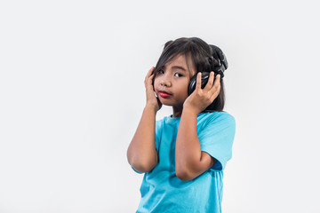 Little girl listening to music on wireless headphones